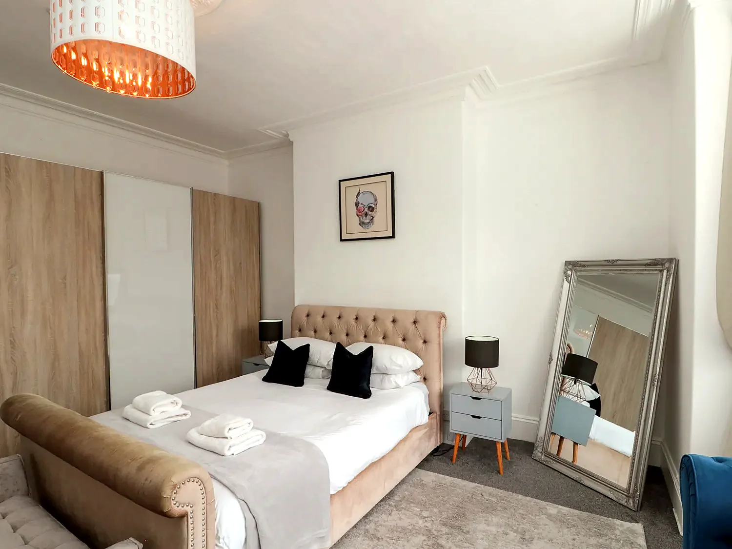 King bedroom with upholstered headboard and bedside tables