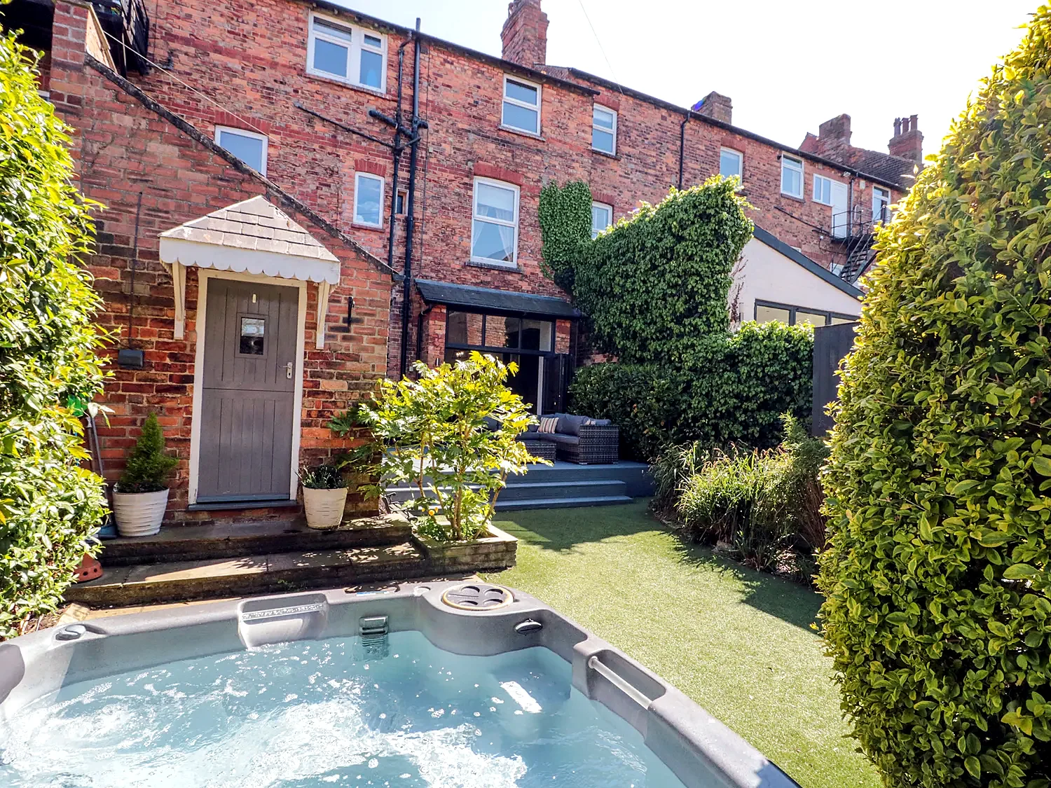 Enclosed patio at Royal Victoria House with outdoor sofa seating and a dining area
