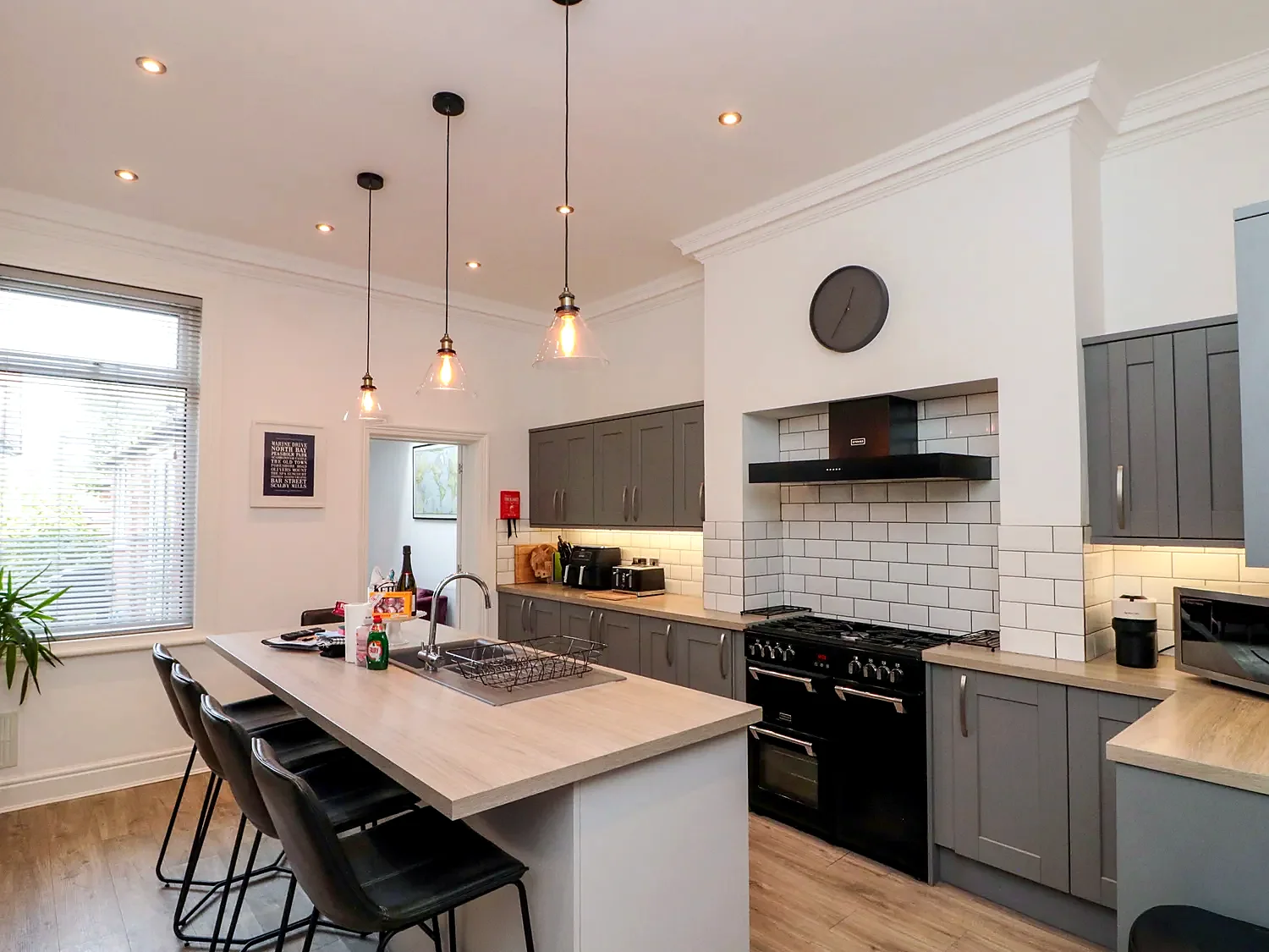 Modern kitchen with range cooker, island breakfast bar and pendant lights