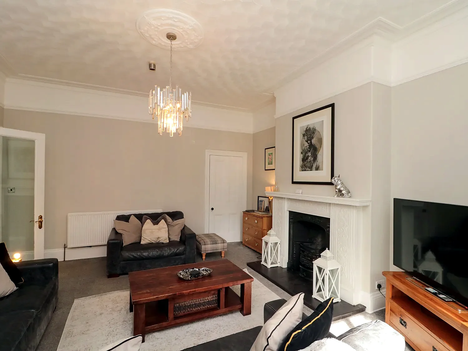 Sitting room with leather sofa, fireplace and television